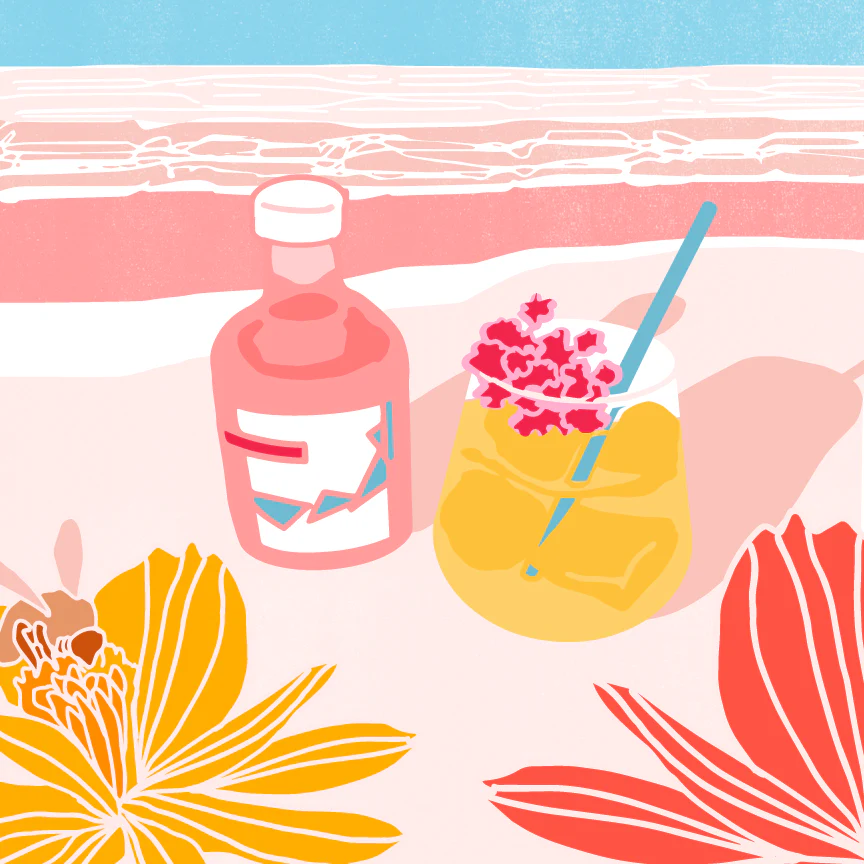 Pink Pacific Rose vinegar bottle beside a floral-garnished spritz glass on a sunlit beach scene