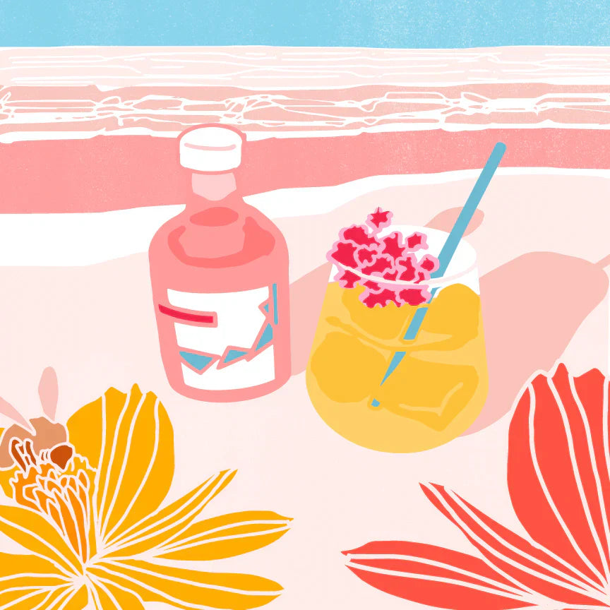 Pink Pacific Rose Spritz cocktail garnished with pink flowers beside a bottle of Pink Pacific Rose vinegar on a pastel beach table