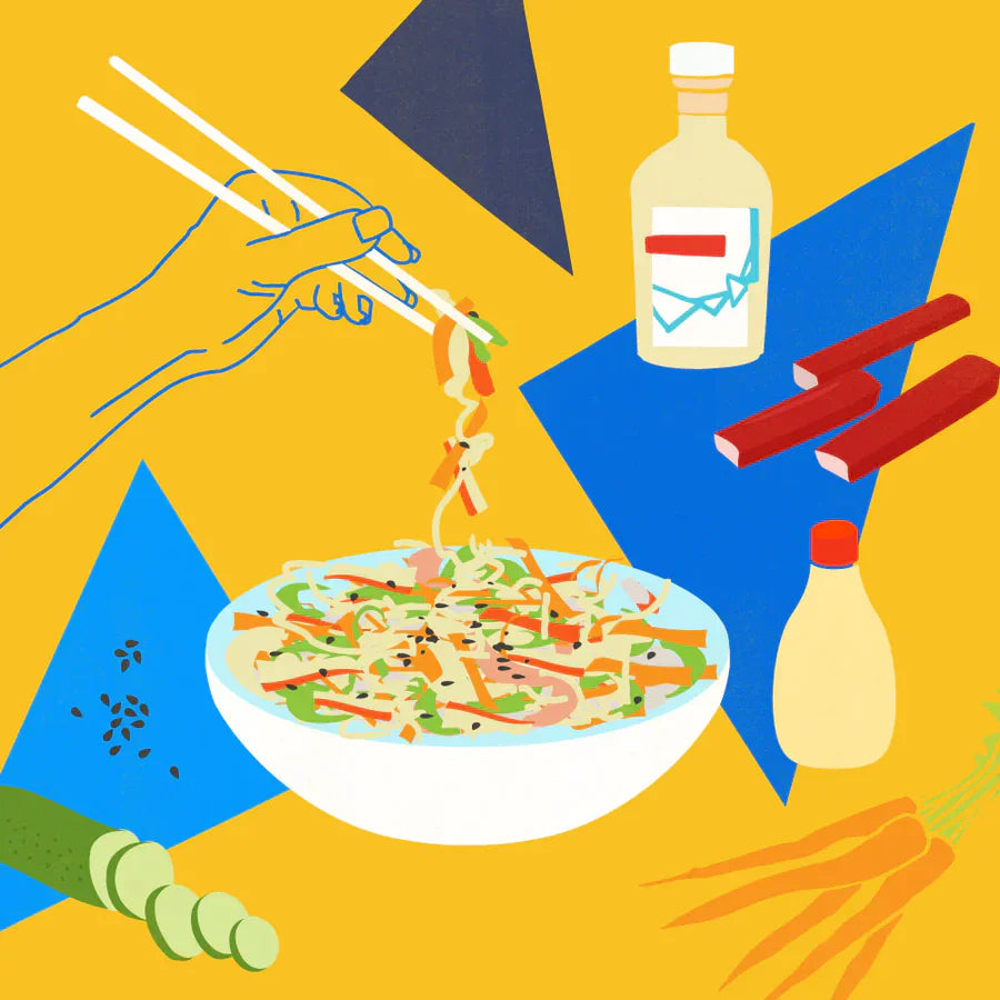 Kani salad lifted with chopsticks on a yellow background with vinegar bottle, imitation crab sticks, cucumber, carrots, and sesame seeds