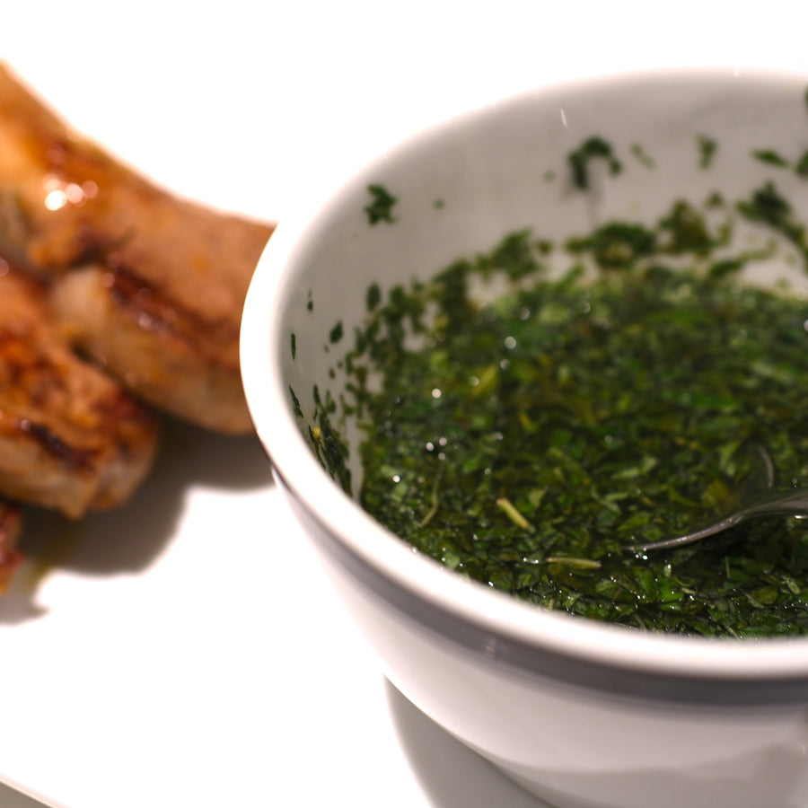 Mint sauce in bowl with lamb chops in background