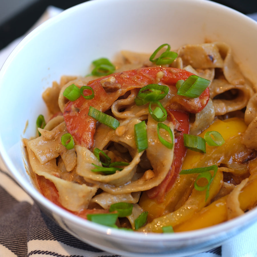 Peanut noodles in bowl on white tea towel