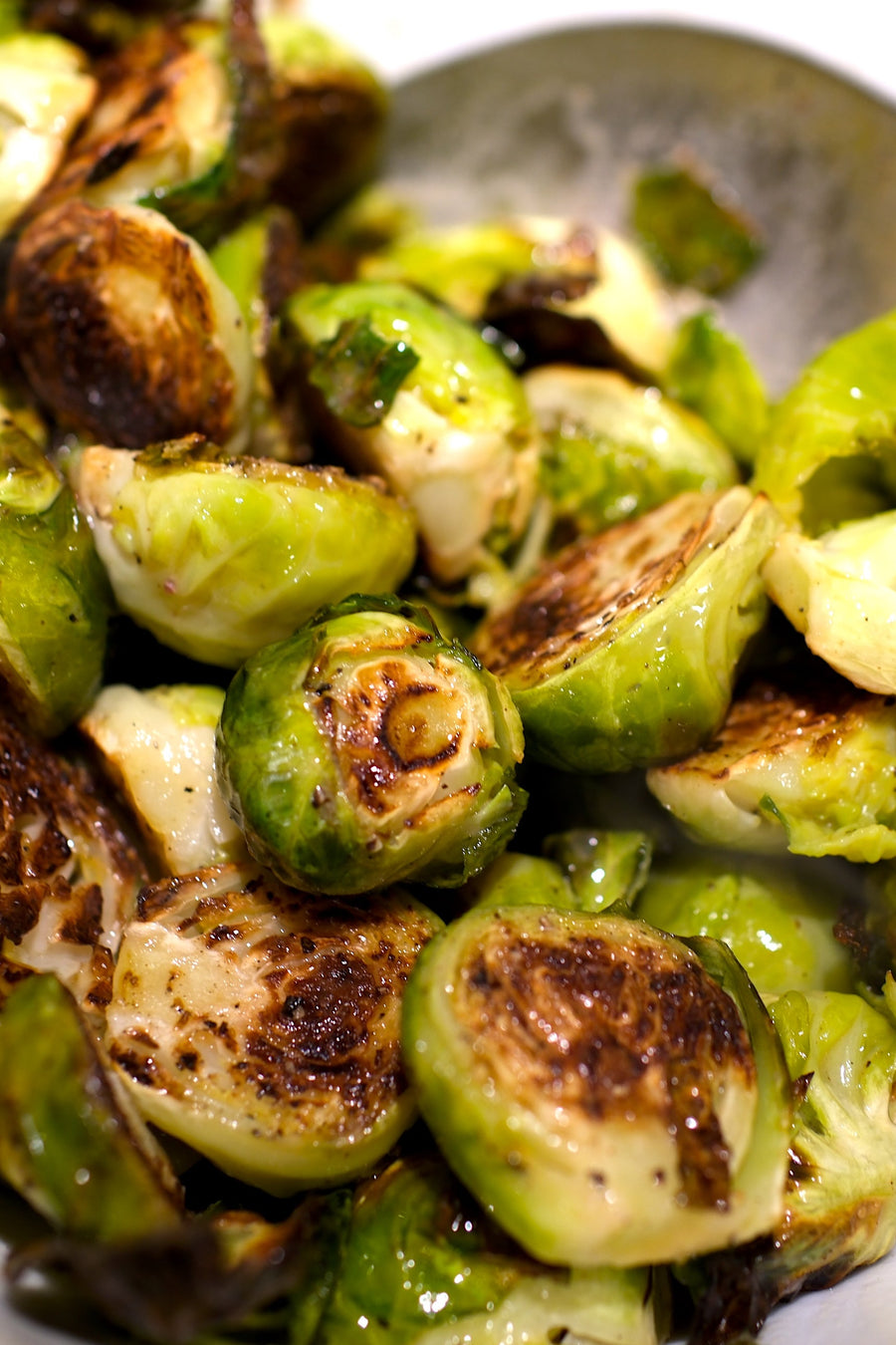 Roasted Brussels Sprouts In White Bowl with Warm Butter & Vinegar Dressing
