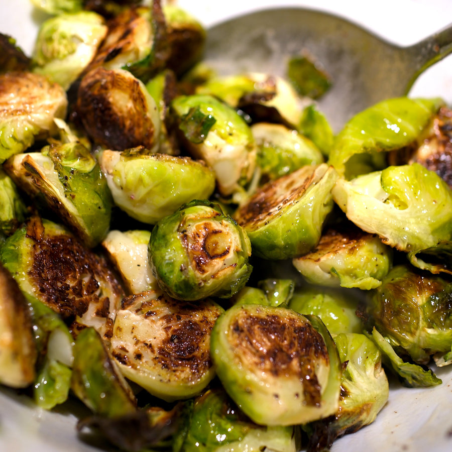 Roasted Brussels Sprouts In White Bowl with Warm Butter & Vinegar Dressing