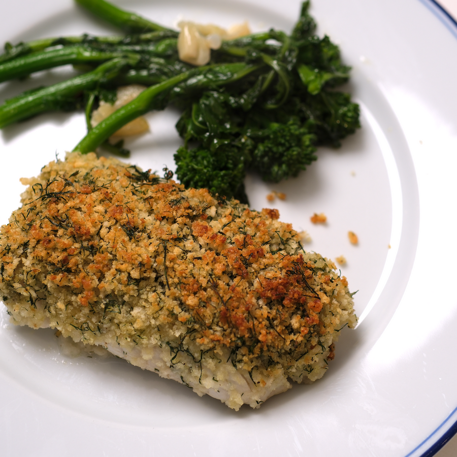 Crusted cod loin on plate with broccoli rabe