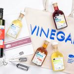 American Vinegar Works bundle: tote, olive oil, 4 vinegars, tea towel, and measuring spoons.