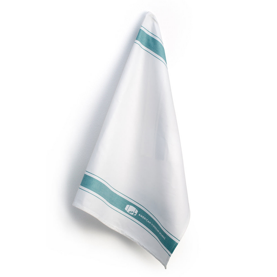 Angled hanging Cotton Tea Towel showing two light green stripes and white American Vinegar Works logo on stripe