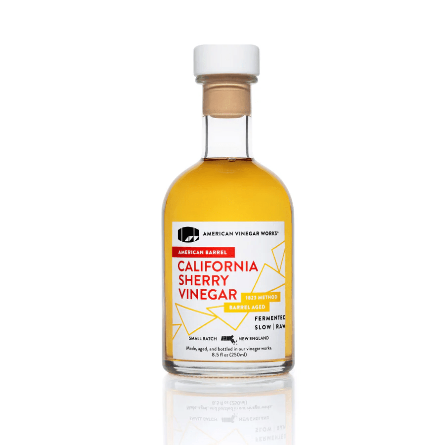 A bottle of American Vinegar Works California Sherry Vinegar with a white cap and yellow-tinted liquid.