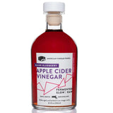 Bottle of Maine Blueberry Apple Cider Vinegar with a white cap and deep reddish-purple liquid.