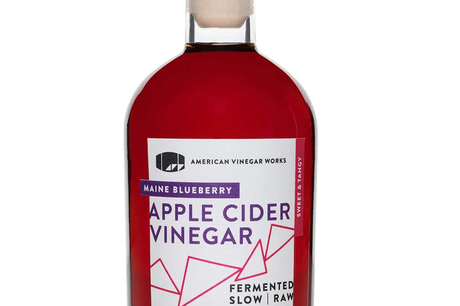 Bottle of Maine Blueberry Apple Cider Vinegar with a white cap and deep reddish-purple liquid.