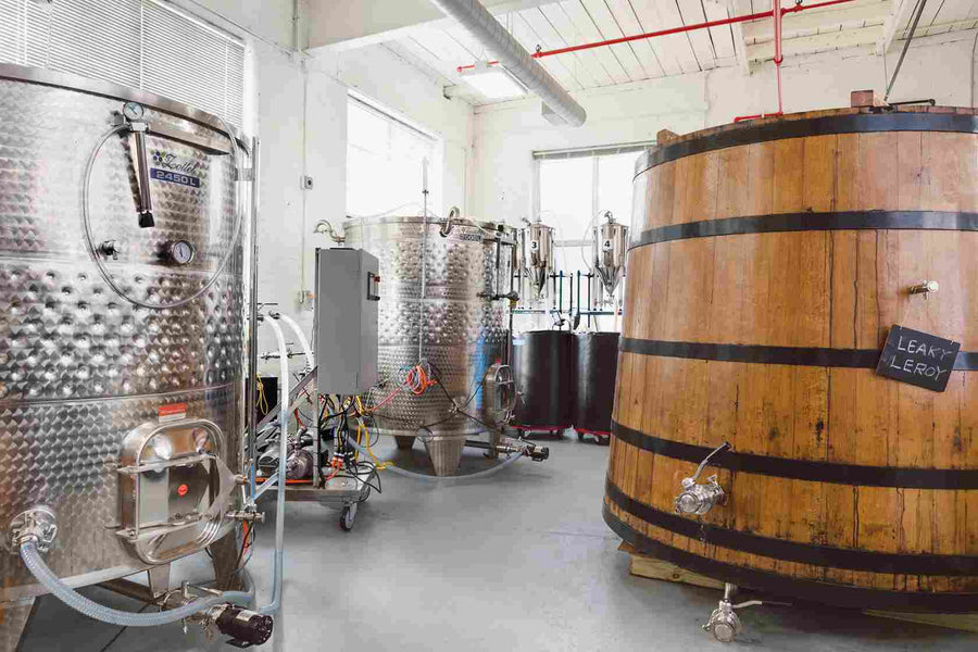 Inside the facility with stainless steel tanks and a wooden aging barrel named "Leaky Leroy."