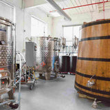 Inside the facility with stainless steel tanks and a wooden aging barrel named "Leaky Leroy."