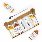 A gift box set from American Vinegar Works containing four small glass bottles of specialty vinegars labeled Maple Cider Vinegar, Maine Blueberry Apple Cider Vinegar, Hot Vinegar, and Apple Cider Vinegar, with an additional bottle of Apple Cider Vinegar placed outside the box. The box insert reads "MOTHER MADE US".