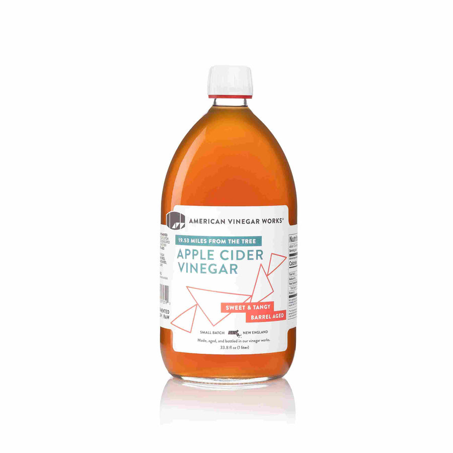 The front view of a large 1 Liter bottle of American Vinegar Works Apple Cider Vinegar, labeled "19.53 Miles From The Tree," featuring a deep amber liquid and a white label with red accents against a clean white background.