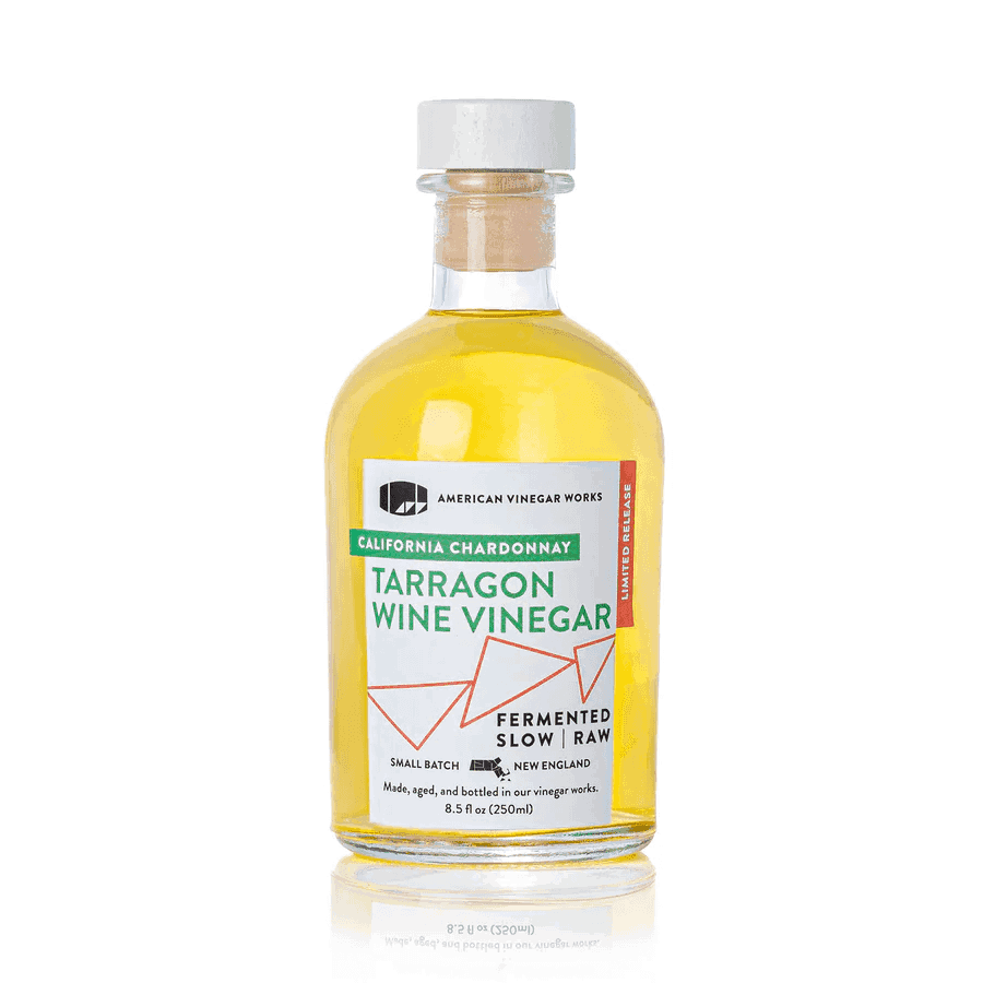The front view of an 8.5 fluid ounce limited release bottle of American Vinegar Works California Chardonnay Tarragon Wine Vinegar, showcasing a bright yellow liquid and a white label with green and orange accents against a clean white background.
