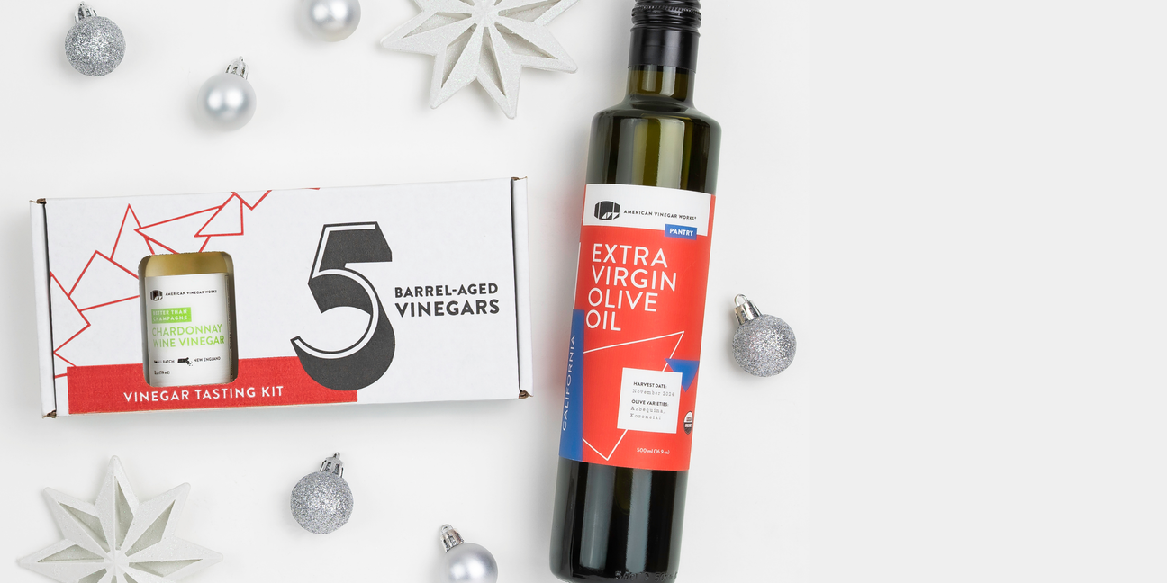 Bottle of olive oil next to a vinegar tasting kit on a white background with decorative elements.