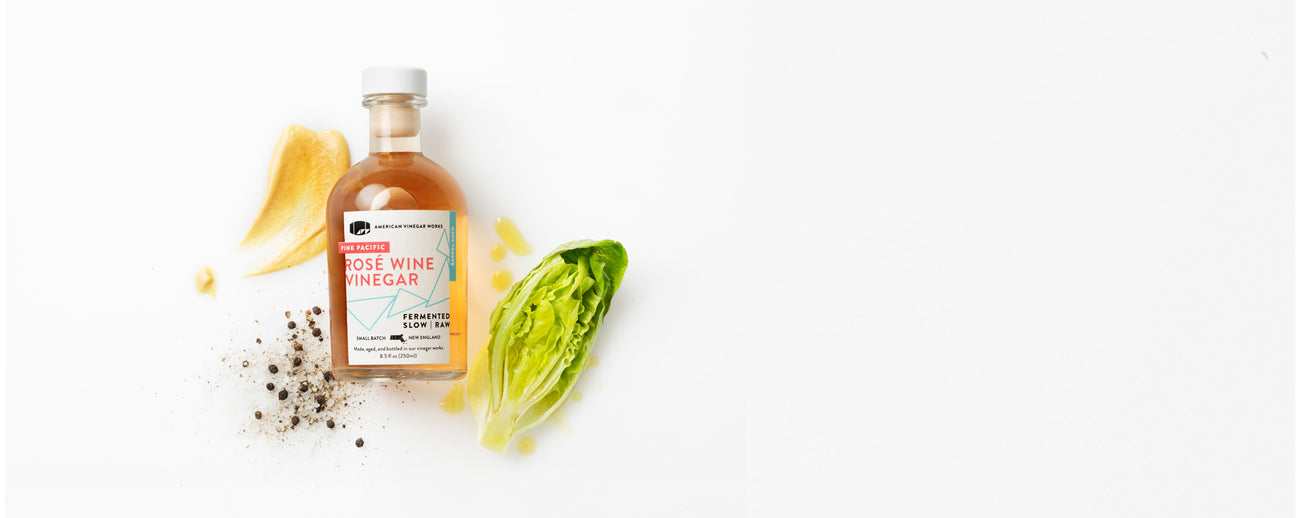 Rose wine Vinegar with vegetables in a white background