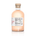 A detailed back view of a large 1.1 Liter bottle of American Vinegar Works Pink Pacific Rosé Wine Vinegar, showing the product description, ingredient list, and nutrition facts panel against a white background.