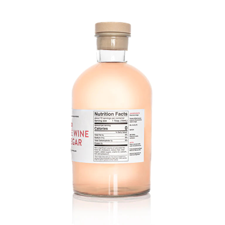 A detailed back view of a large 1.1 Liter bottle of American Vinegar Works Pink Pacific Rosé Wine Vinegar, showing the product description, ingredient list, and nutrition facts panel against a white background.