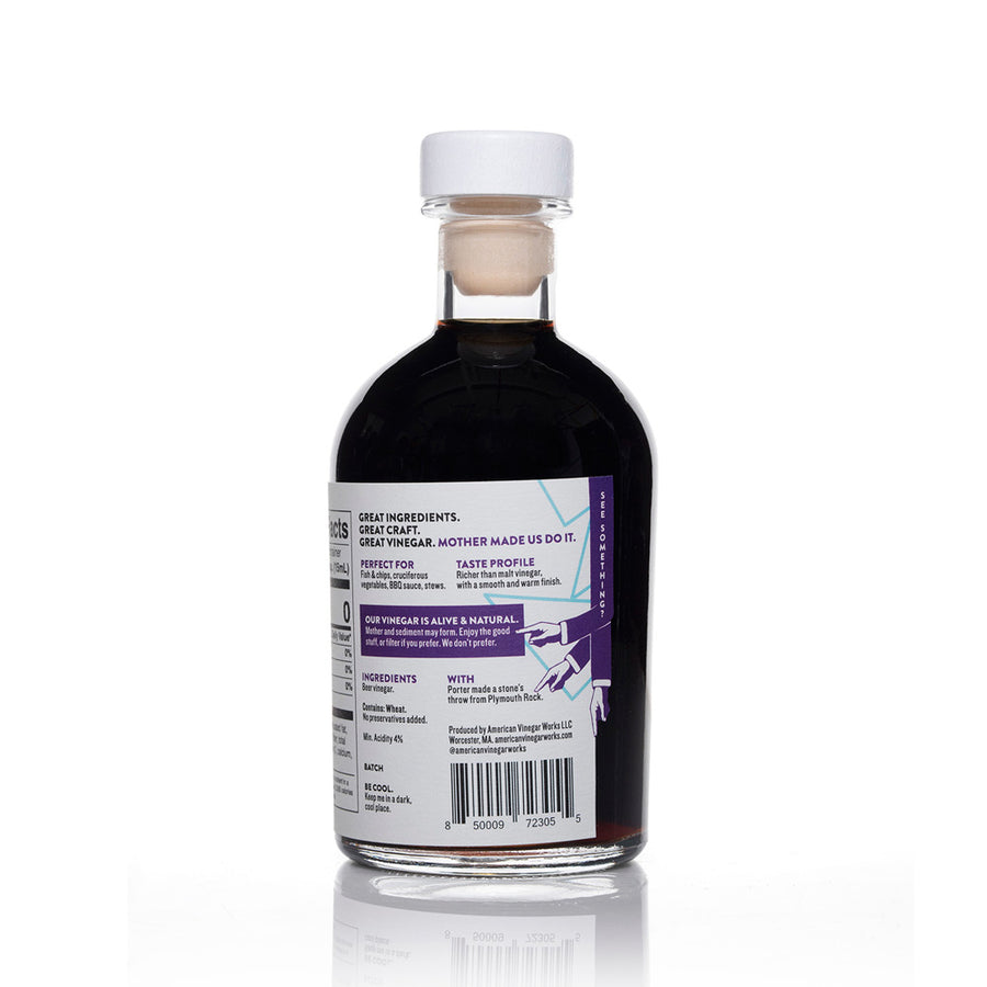 A detailed back view of an 8.5 fluid ounce bottle of American Vinegar Works Porter Beer Malt Vinegar, showing the perfect food pairings, a taste profile with a smooth and warm finish, and nutrition facts panel against a white background.