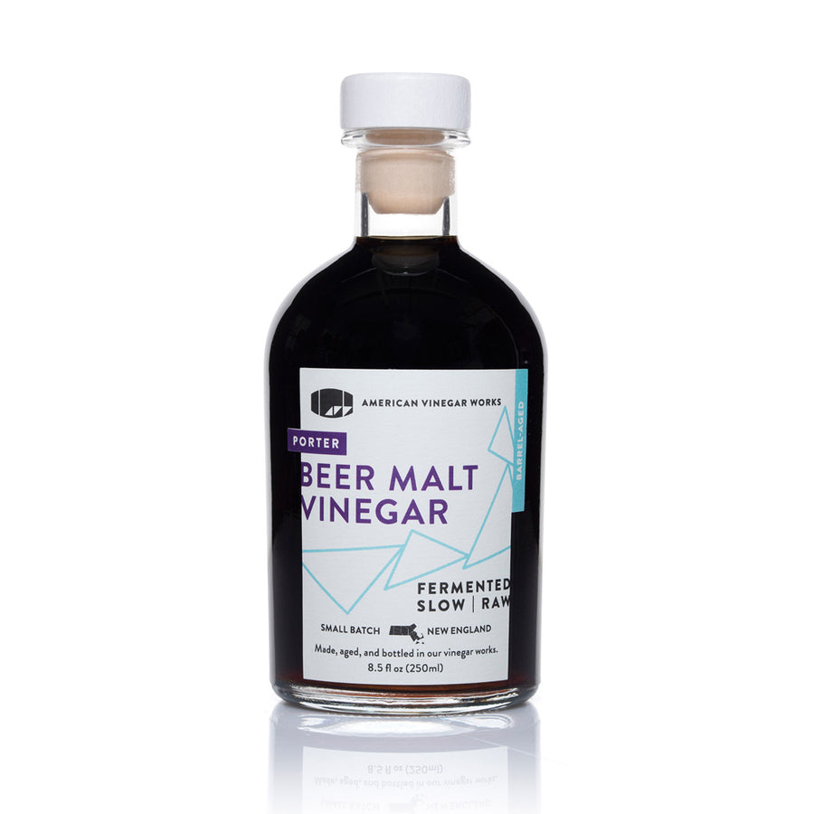 The front view of an 8.5 fluid ounce bottle of American Vinegar Works Porter Beer Malt Vinegar, showcasing a dark liquid and a white label with purple accents and geometric lines against a clean white background.