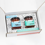 A square-cropped top-down view of the open American Vinegar Works Jam Gift Set, showing two jars of jam nestled inside custom illustrated box packaging.