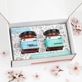 Two jars of jam in a decorative box with cherry blossoms around