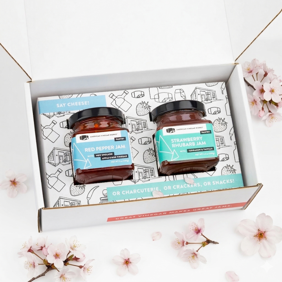 Two jars of jam in a decorative box with cherry blossoms around