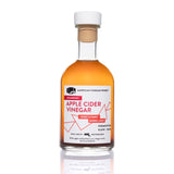 Cranberry Apple Cider Vinegar clear glass bottle on white background — artisanal infused vinegar