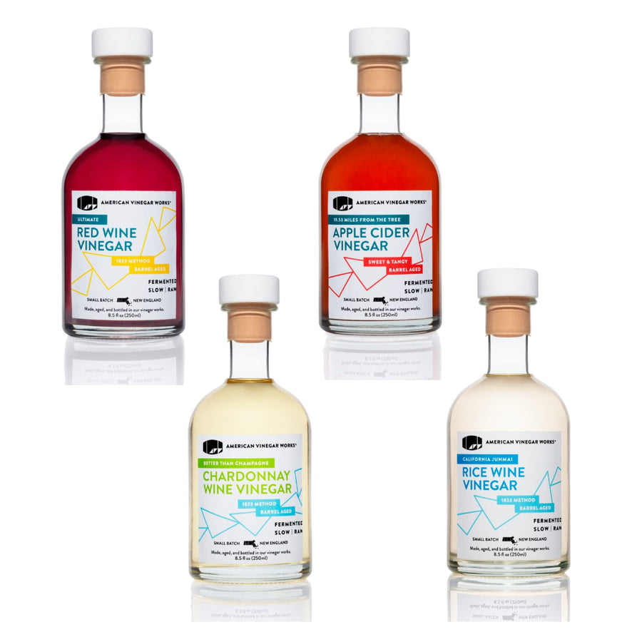 Four bottles of different types of vinegar on a white background