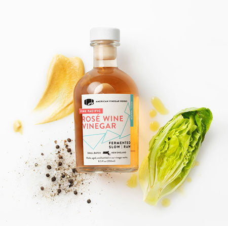 Rose wine vinegar with vegetables in a white background