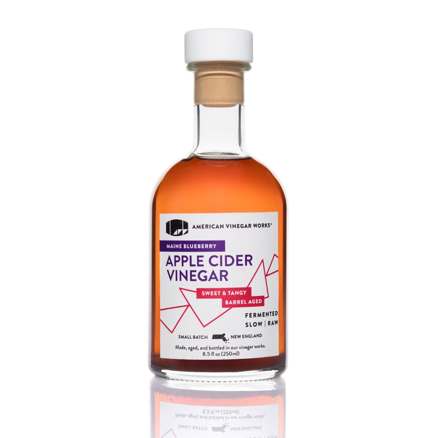 Front view of 8.5oz Blueberry Apple Cider Vinegar: deep red liquid, white/purple/pink label on white